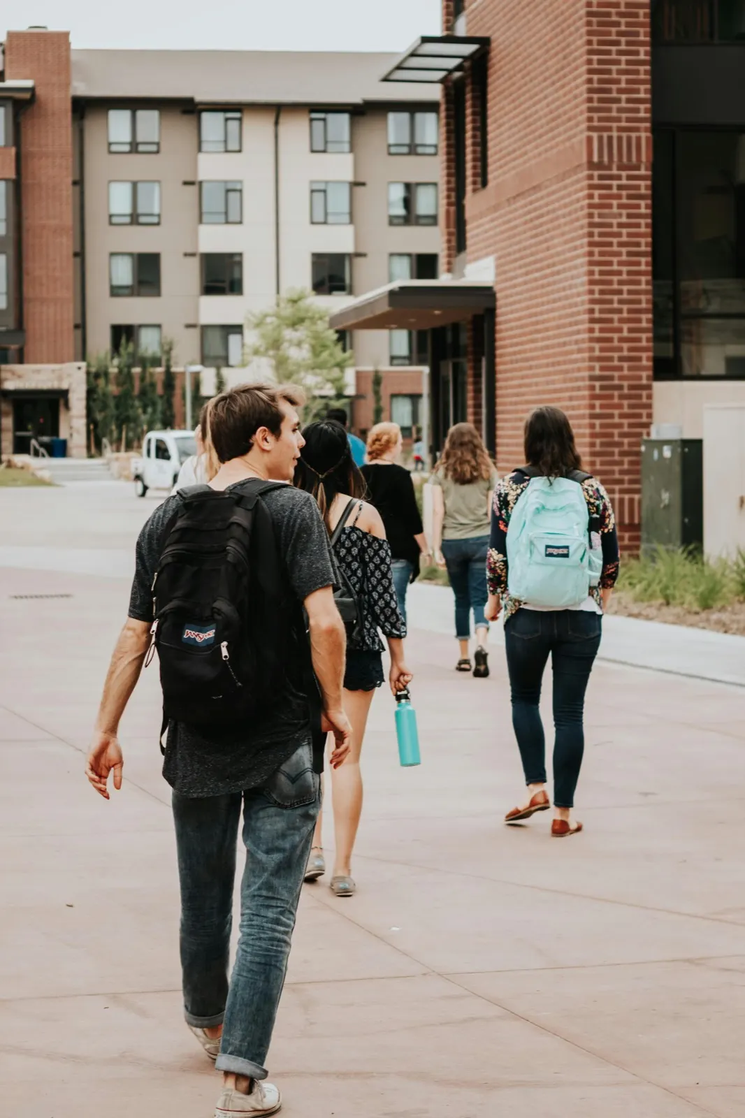A parent walking through campus with two students